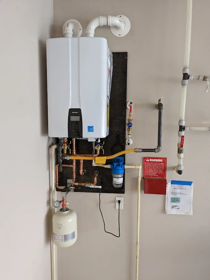 Professional plumber installing copper piping in a West Mead home